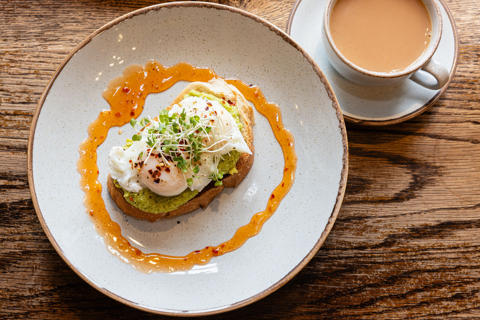 Poached eggs and smashed avocado on toast with a pot of tea