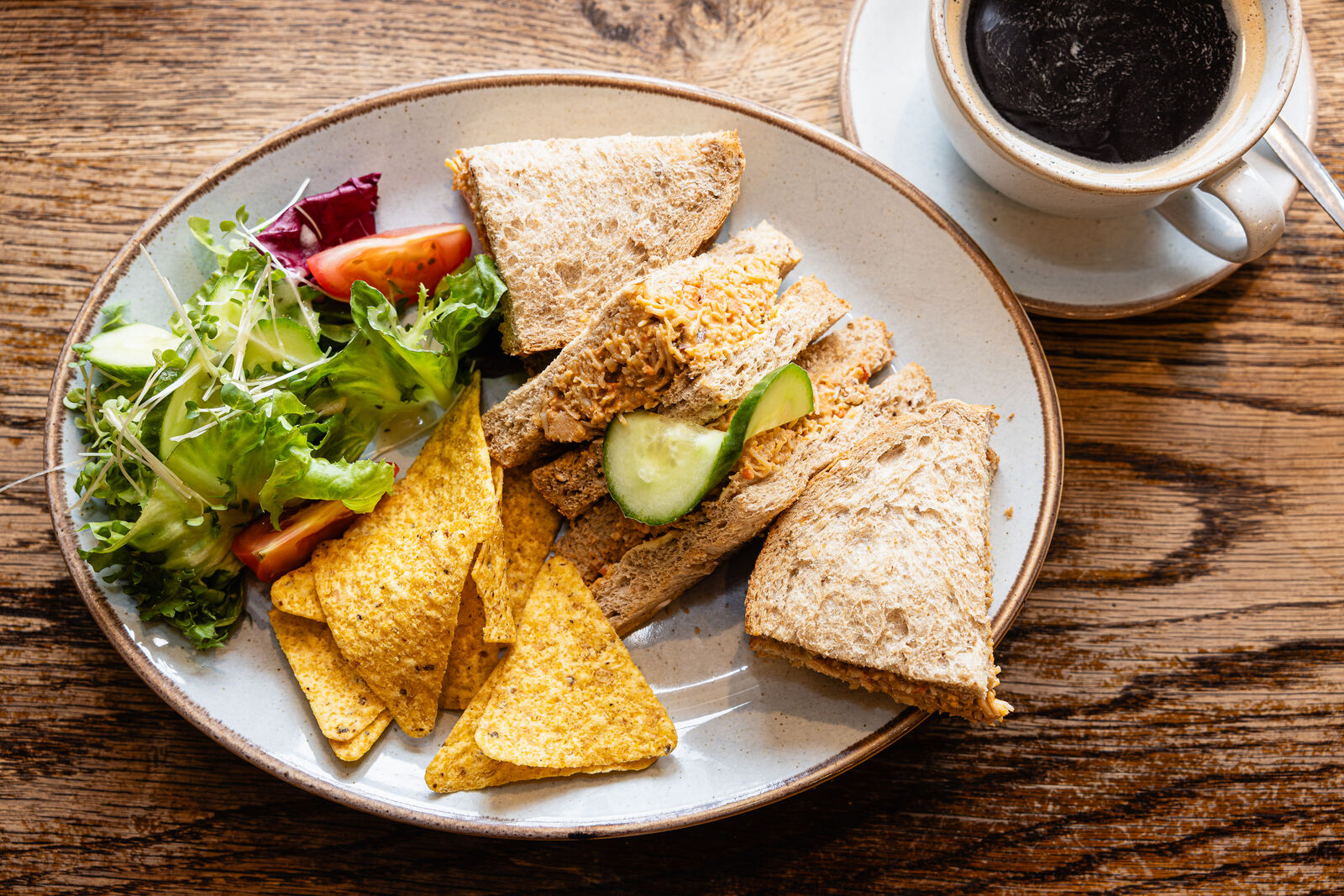 A fresh sandwich platter with salad and tortilla chips